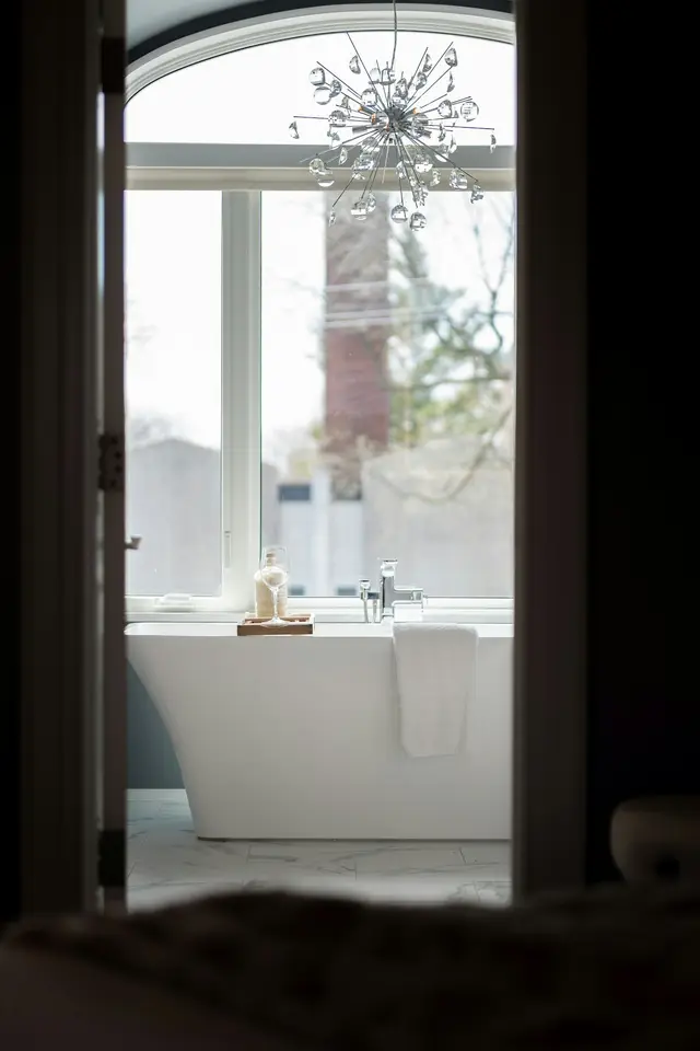 Freestanding bath beside a large window