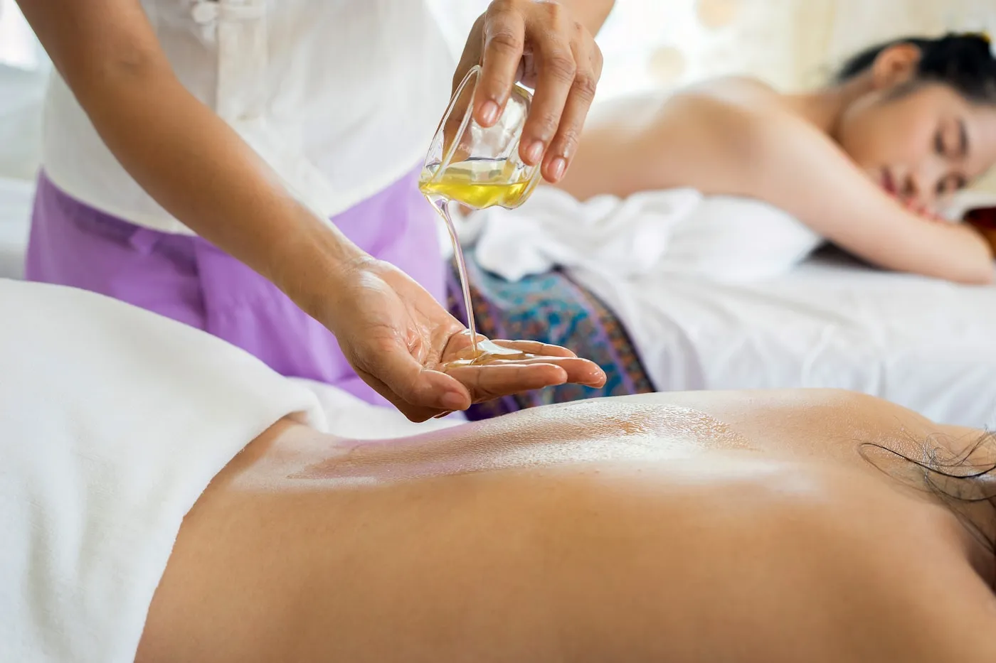 Sports massage therapist applying treatment oil