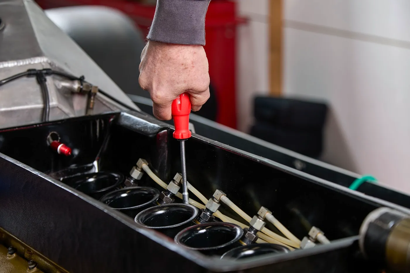Mechanic working on a car engine with hand tools